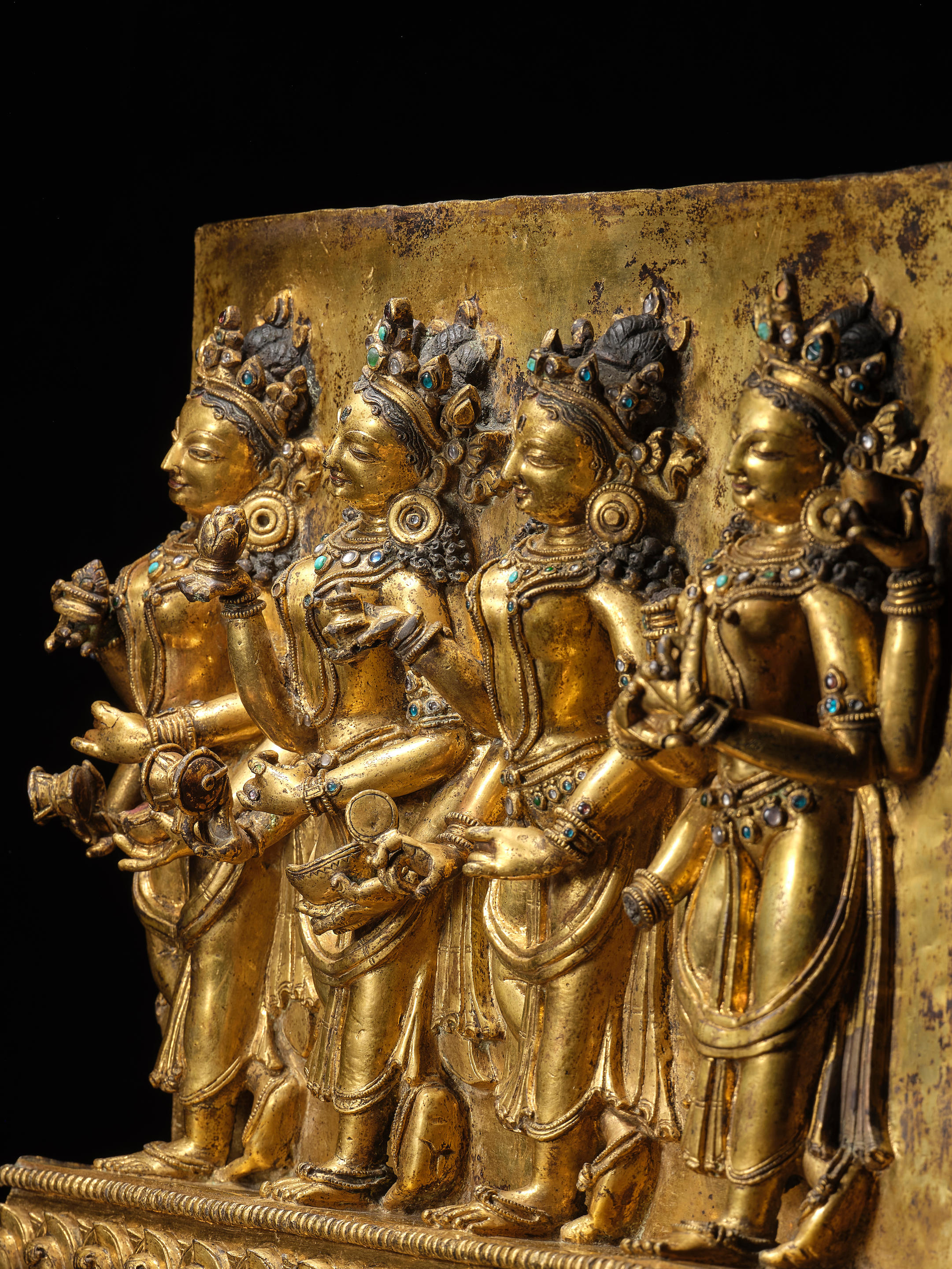 Bonhams : A CAST GILT COPPER ALLOY PANEL WITH OFFERING GODDESSES DENSATIL,  CENTRAL TIBET, 14TH CENTURY